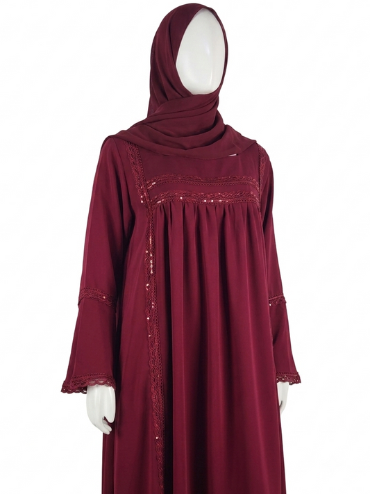 A deep burgundy long-sleeved modest dress with a matching headscarf, displayed on a white mannequin against a plain white background.
